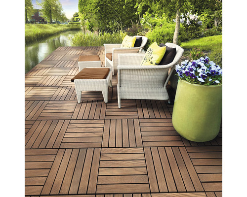 Terrasse avec dalles en bois, fauteuils en rotin et pot de fleurs
