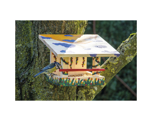 Maison à oiseaux en bois avec nourriture et mésange bleue sur un arbre