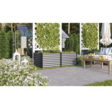 Scène de jardin avec des plates-bandes surélevées en métal, une serre et des meubles de jardin