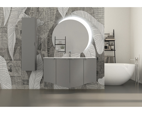 Badezimmer mit Waschtischunterschrank, Spiegelschrank, rundem Spiegel mit Beleuchtung und Badewanne vor einer gemusterten Wand