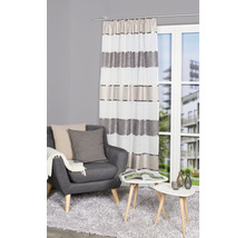 Salon avec fauteuil, table et rideau rayé