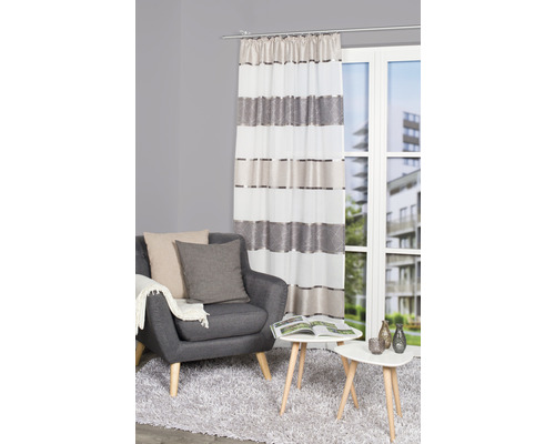 Salon avec fauteuil, table et rideau rayé