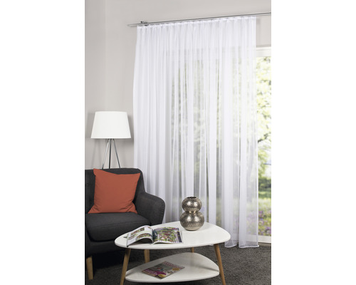 Wohnzimmer mit weißem, transparentem Gardinenschal vor einem Fenster