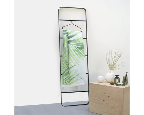 Schwarzer Handtuchhalter mit Handtuch mit Blättermuster an einem Kleiderbügel