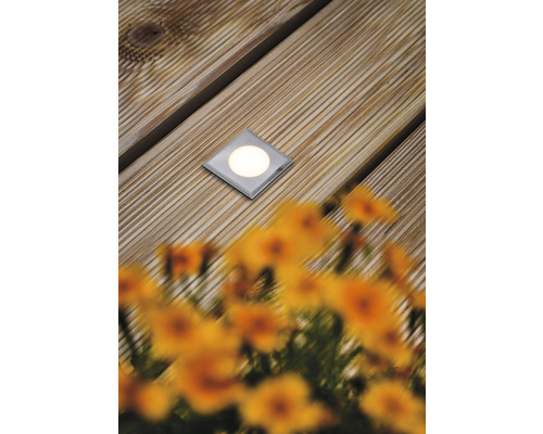 Bodeneinbaustrahler auf Holzterrasse mit Blumen im Vordergrund