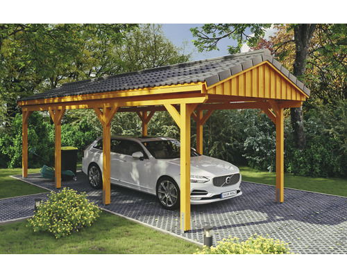 Carport simple SKAN Holz Fichtelberg 317 x 808 cm chêne clair Abri de voiture en bois avec une voiture en dessous, entouré d''arbres et d''arbustes.