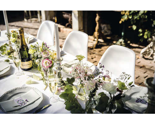 Table dressée pour une fête avec champagne, bougies et fleurs
