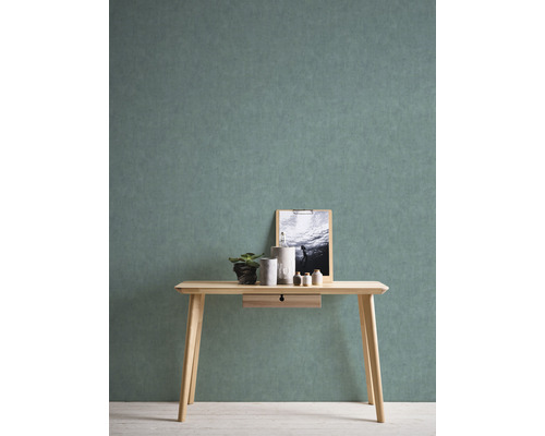 Table en bois clair avec tiroir, décoration et image devant un mur