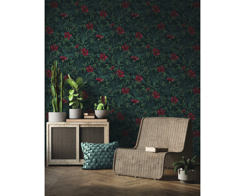 Salon avec papier peint hibiscus, fauteuil en rotin et plantes d''intérieur sur une armoire