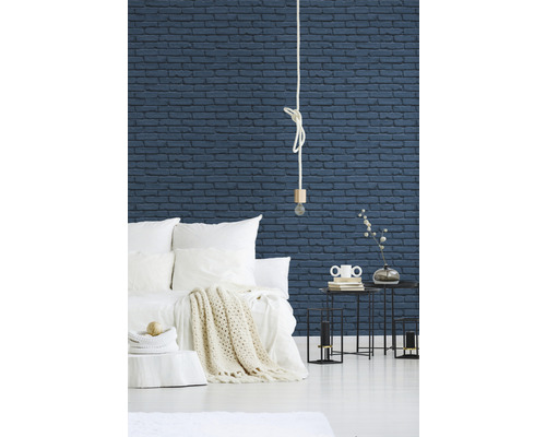Schlafzimmer mit Bett, Nachttischen und einer Wand mit Backsteinoptik