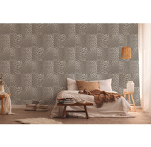 Chambre à coucher avec un papier peint à motif de peau d''animal et un lit double.