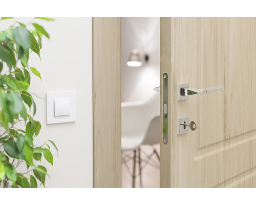 Geöffnete Holztür mit Türklinke in einem hellen Raum