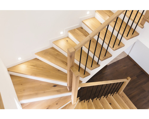 Holztreppe mit Geländer und Stufenbeleuchtung von oben fotografiert