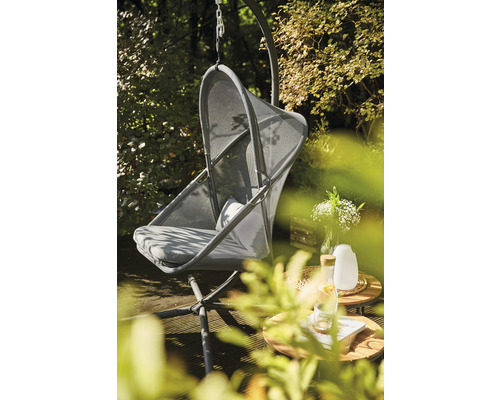 Hängesessel mit Gestell und zwei Tischen im Garten