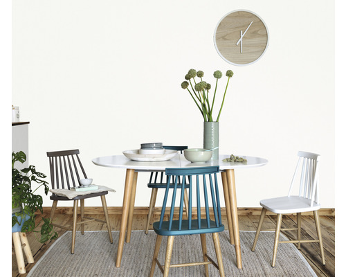 Esstisch mit Stühlen, Geschirr und Blumenvase in einem hellen Raum