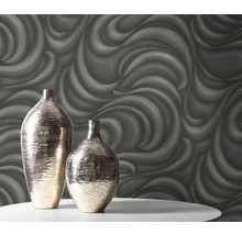 Deux vases décoratifs sur une table devant un papier peint à motif ondulé