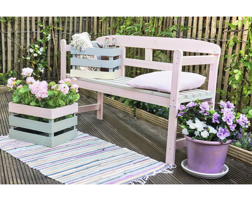 Scène de jardin avec un banc en bois, des jardinières et un tapis