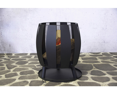 Brasero en métal avec bois de chauffage sur un sol en pierre