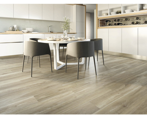 Cuisine claire avec parquet, table à manger et chaises.