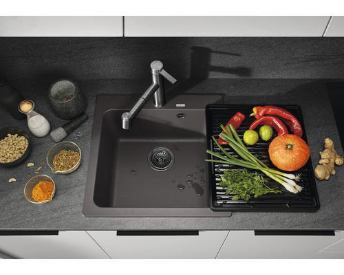 Évier de cuisine gris foncé avec robinetterie et légumes