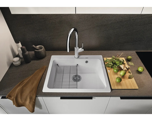 Évier avec égouttoir, robinetterie et ustensiles de cuisine sur un comptoir de cuisine