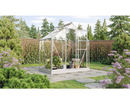 Serre de jardin avec plantes et outils de jardin dans le jardin