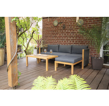 Scène de jardin avec ensemble de salon, table, boissons et plantes sur une terrasse