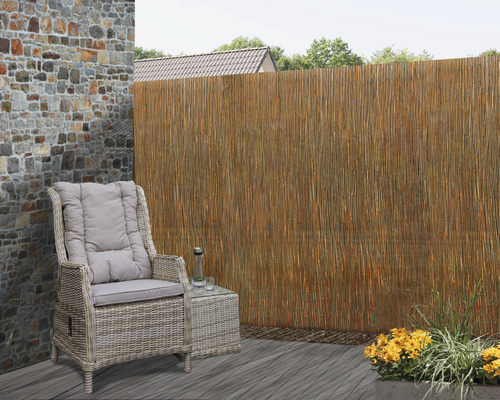 Terrassenszene mit Rattanmöbeln und Rohrmatte als Sichtschutz