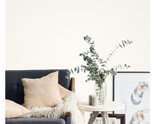 Wohnzimmer mit grauem Sofa, Kissen, Beistelltisch, Vase mit Eukalyptus und Bilderrahmen.