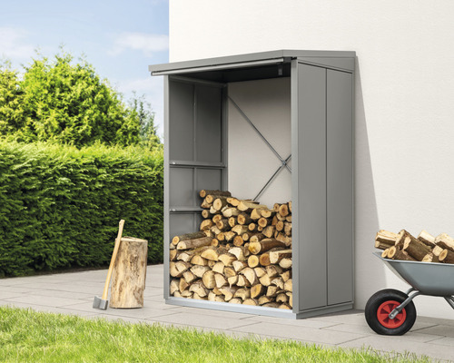 Holzlager mit Brennholz, Axt und Schubkarre im Garten