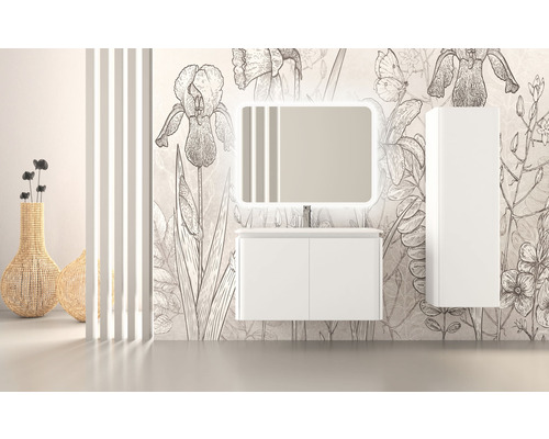 Salle de bain avec meuble sous-lavabo, miroir éclairé et armoire haute devant un papier peint floral