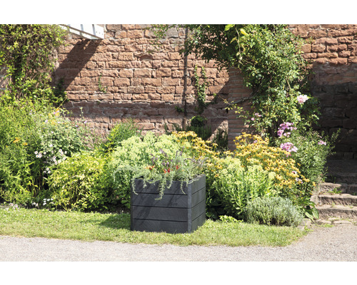 Quadratischer Pflanzkasten aus Kunststoff in einem Garten mit Blumen