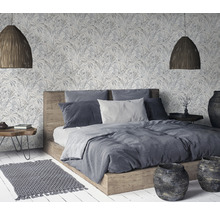 Chambre avec lit double, papier peint à motifs, lampes tressées et décoration