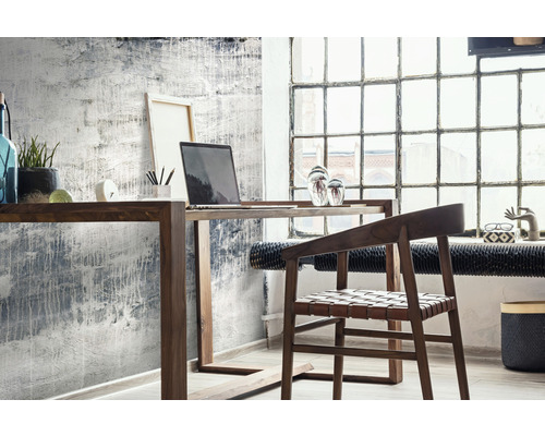 Büroszene mit Holzschreibtisch, Laptop und Stuhl vor einer strukturierten Wand