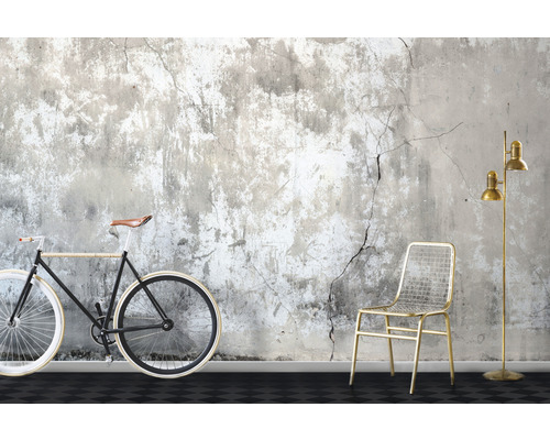 Szene mit Fahrrad, Stuhl und Stehlampe vor einer beschädigten Wand