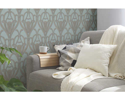 Salon avec papier peint à motifs floraux, canapé, coussins et couverture