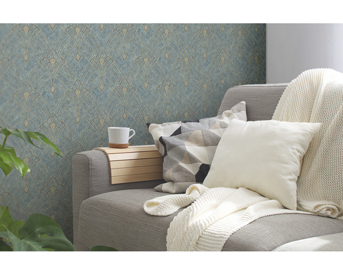 Salon avec un canapé gris, des coussins, une couverture, une table d''appoint avec une tasse et du papier peint à motifs