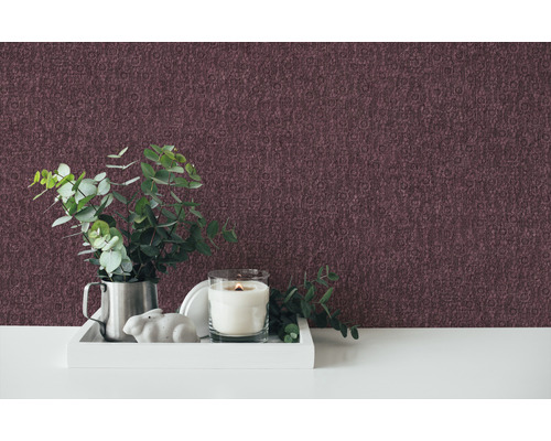 Chambre décorative avec papier peint à motifs, bougie, plante et figurine décorative