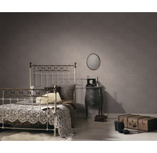 Schlafzimmer mit Bett, Nachttisch und gemusterter Tapete für eine gemütliche Atmosphäre.