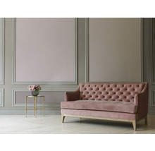 Canapé rose à boutons dans une pièce décorée