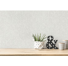 Pièce lumineuse avec papier peint à motifs et éléments décoratifs sur une table en bois