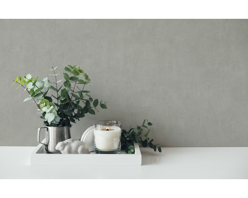 Dekorative Szene mit Eukalyptus in einem Krug, Kerze im Glas und Hasenfigur auf einem Tablett