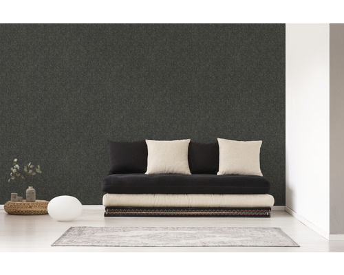 Wohnraum mit dunkler Strukturtapete, Sofa und Teppich für eine moderne Raumgestaltung