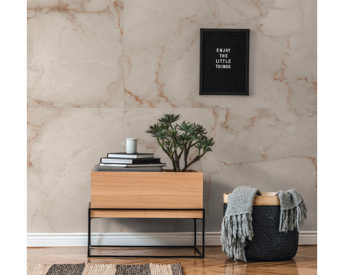 Aménagement mural avec des carreaux de marbre dans des tons clairs, combiné avec une armoire en bois sur un cadre métallique et des accessoires décoratifs.