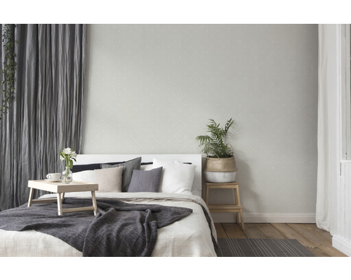 Chambre lumineuse avec lit, rideaux et plantes