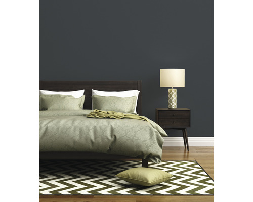 Chambre à coucher avec lit, lampe de chevet et tapis à chevrons