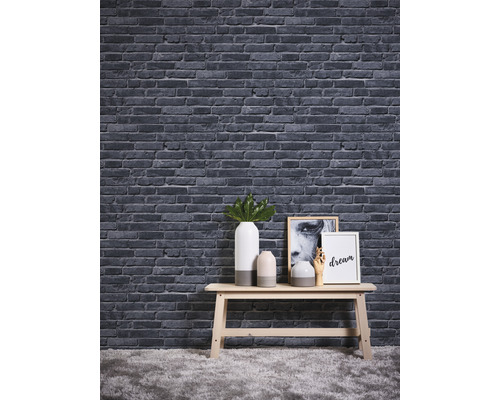 Papier peint décoratif aspect pierre au-dessus d''une table avec des vases et des tableaux.