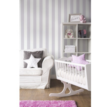 Babyzimmer mit Wiege, Regal, Sessel und gestreifter Tapete