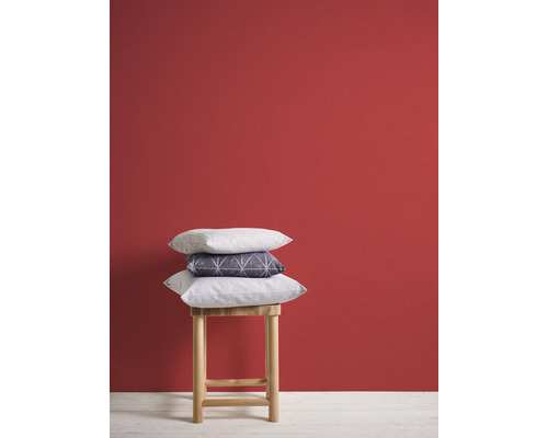 Coussins décoratifs sur un tabouret en bois devant un mur