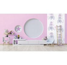 Helles Kinderzimmer mit rosa Wand, weißem Schrank, Stuhl und Elefantentapete